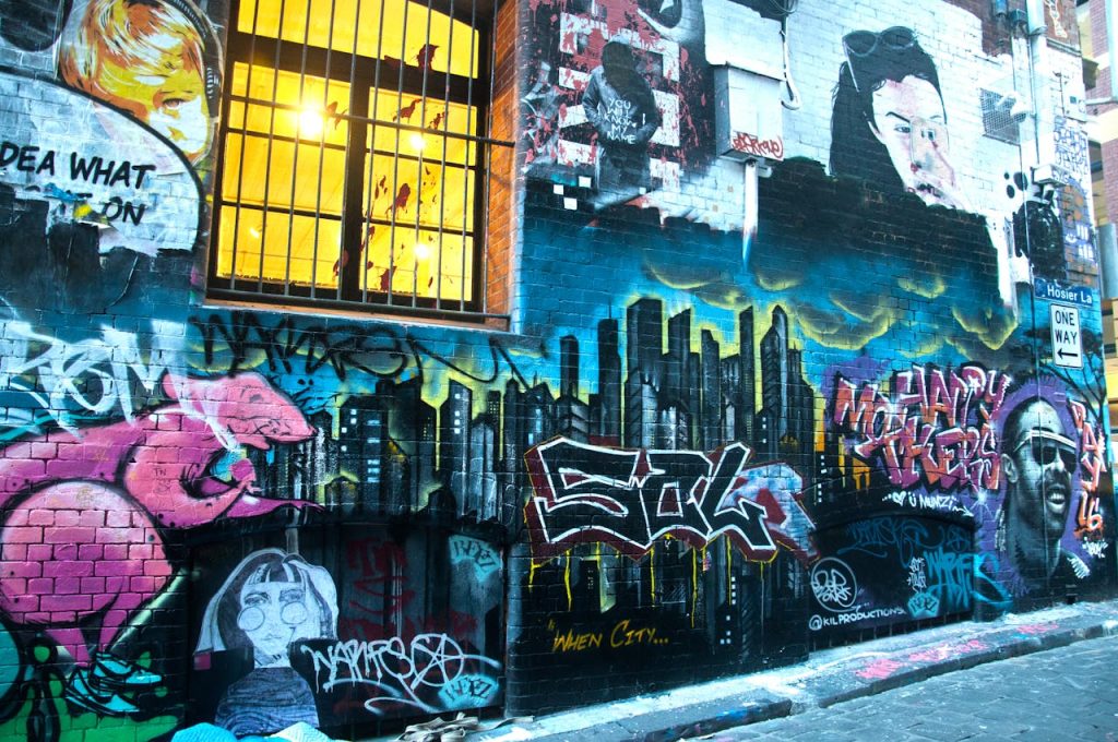 Vivid graffiti art on an urban brick wall in a city alleyway.